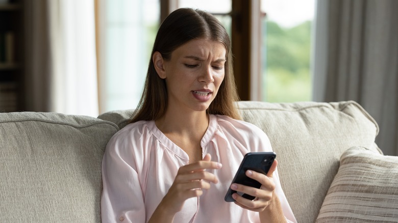 concerned woman looking at her phone