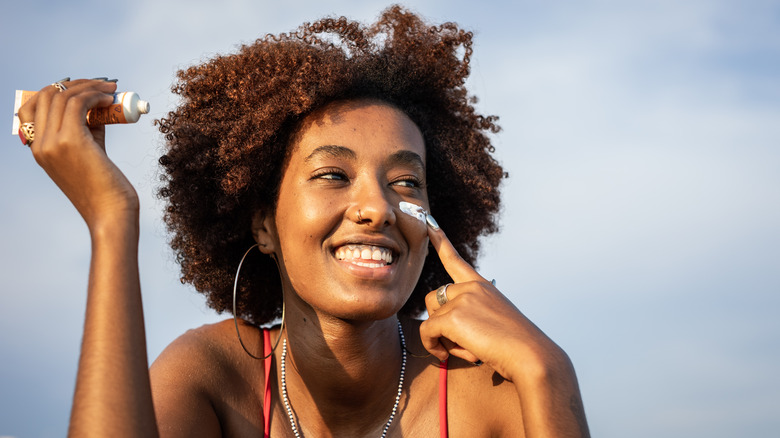 Woman applying SPF to face