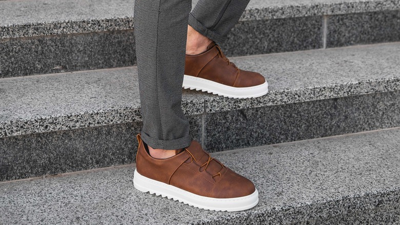 Man wearing brown leather sneakers
