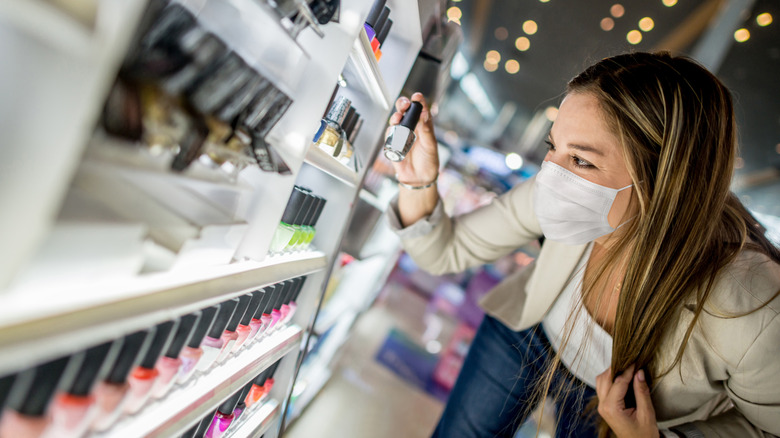 masked woman checking cosmetics