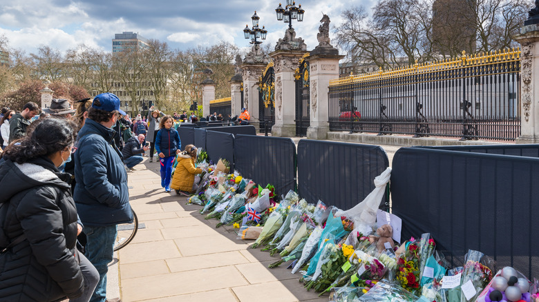 People grieving with flowers