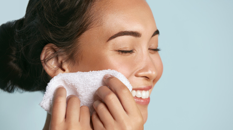 Woman drying off her face with a towel