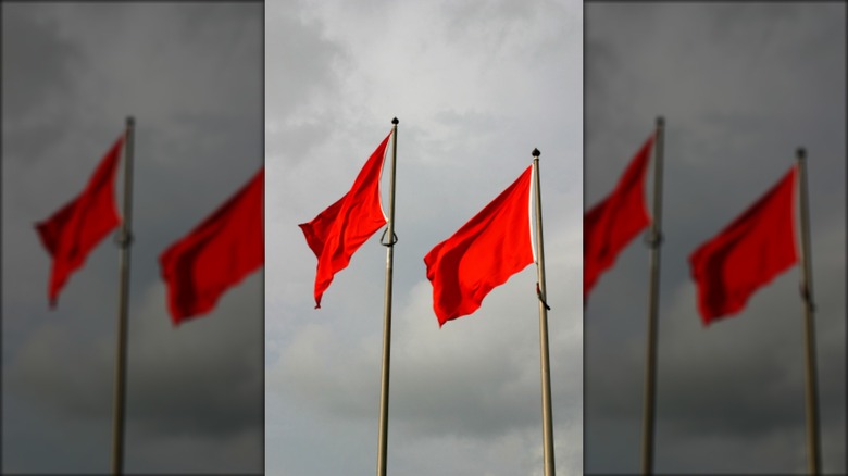 red flags against cloudy sky