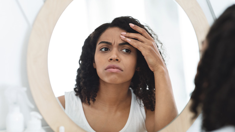 woman looking into mirror