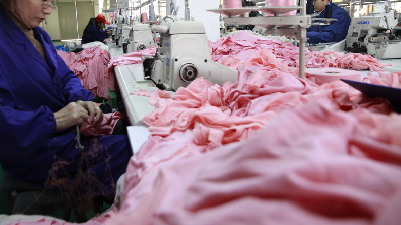 Row of workers at sewing machines in Chinese clothing factory