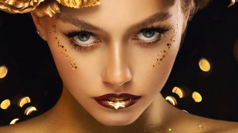 Woman's face with gold makeup