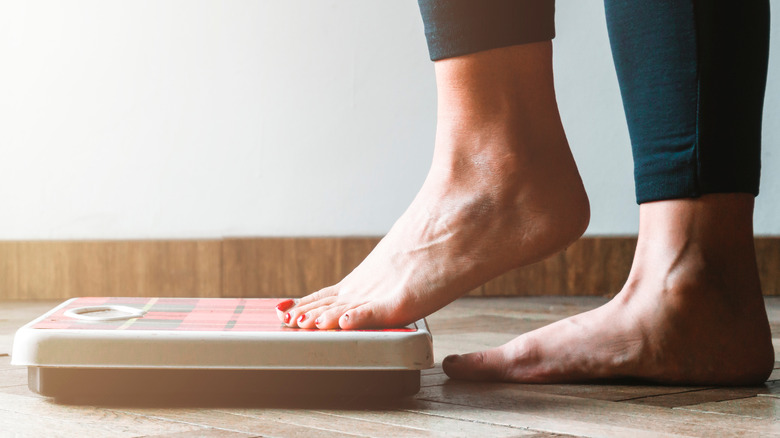 woman stepping onto scale