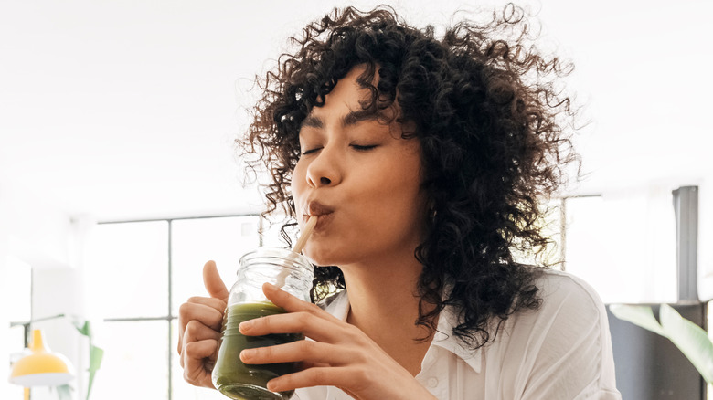 Model drinking green juice