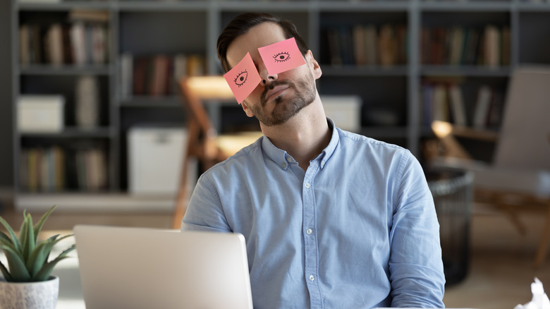 Bored worker with post-it note eyes