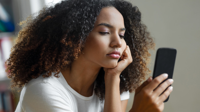 Woman frowns at phone