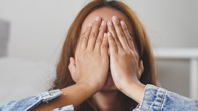 woman covering eyes