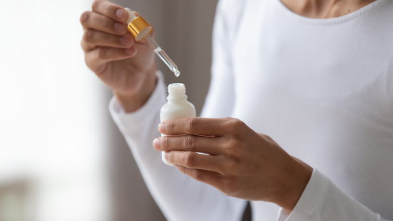 woman holding serum and pipette