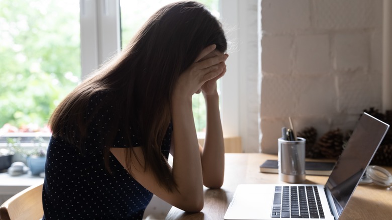 Woman cries at work desk