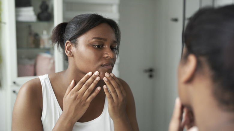 A woman popping a pimple