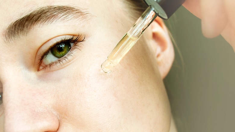 woman applying oil on her face