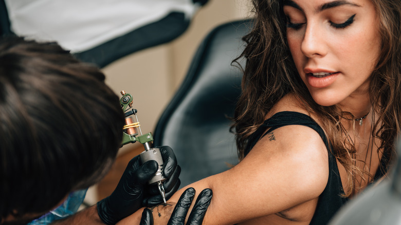 Woman getting tattoo on arm