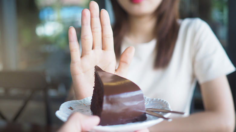 Woman refusing chocolate cake 