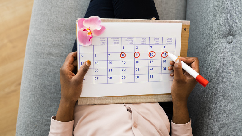 Woman tracking period on calendar 