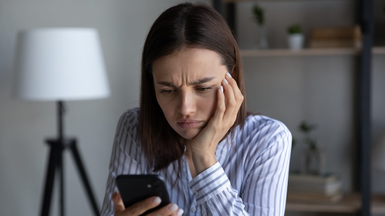 Woman frowns at phone