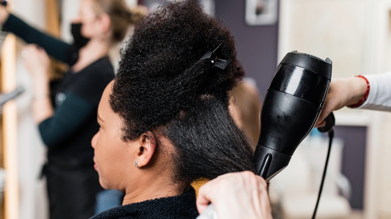 woman blow-drying hair salon