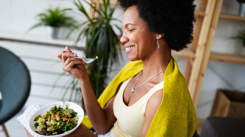 smiling woman eating salad