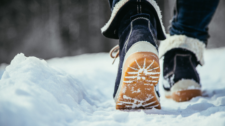 Close-up of boots walking through snow