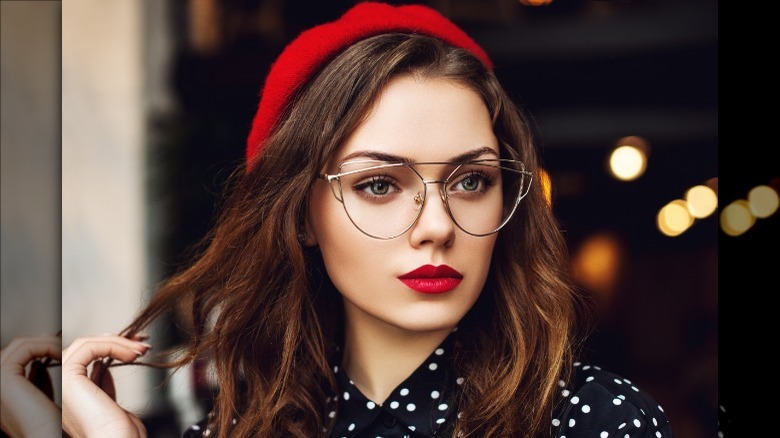 Woman wearing glasses and a red hat