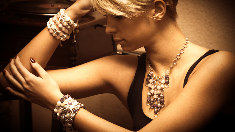 Woman wearing big necklace and bracelets on each wrist