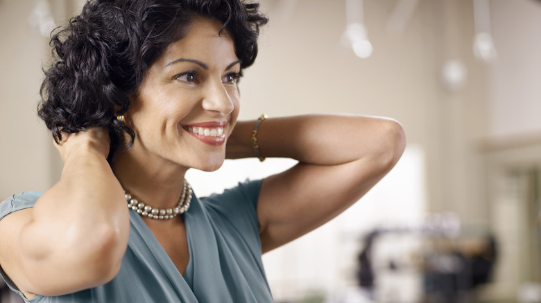 Woman putting necklace on