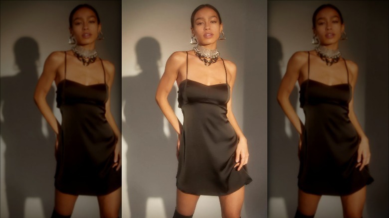 UO model wears strappy black mini dress