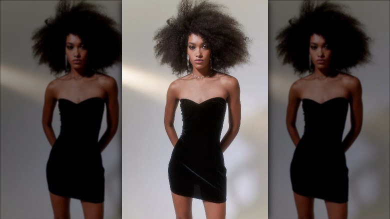 Urban outfitters model poses in velvet black dress 