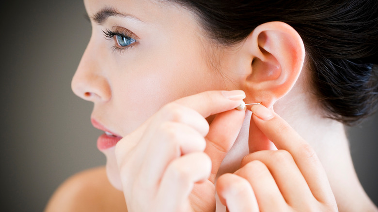 Woman putting in a stud earring