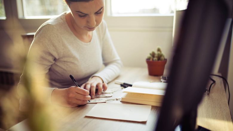 Woman writing in card at desk