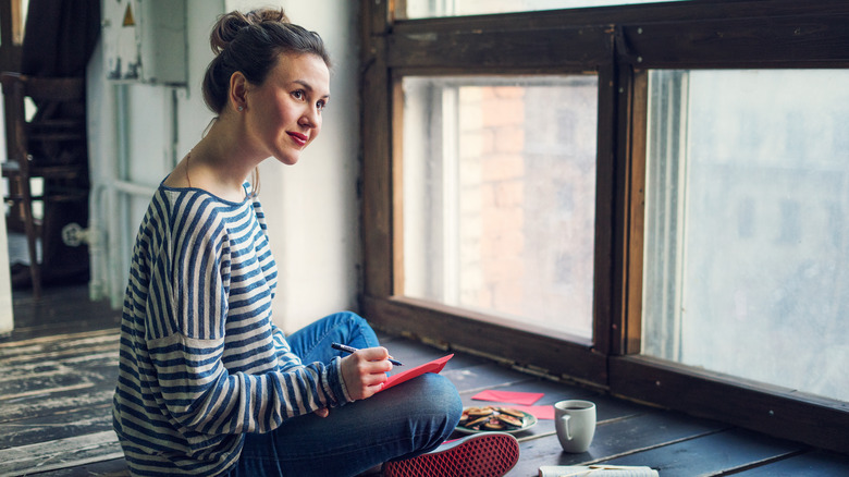 Woman writing in card on floor