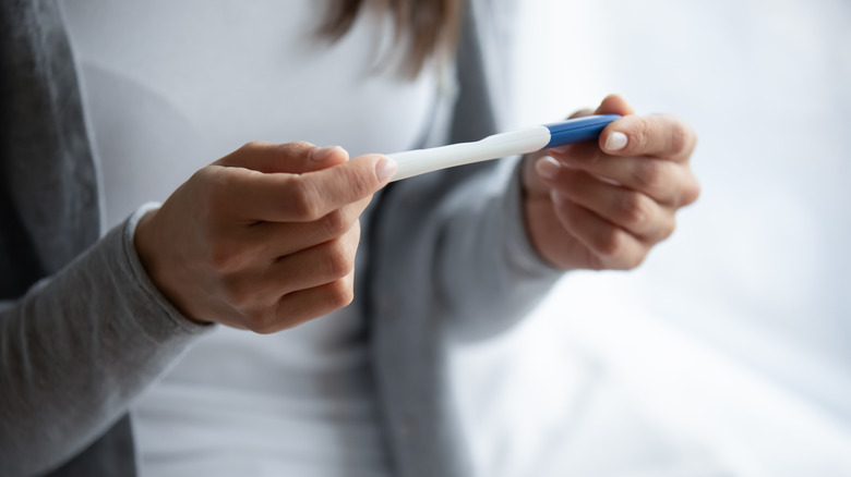 Woman holding pregnancy test