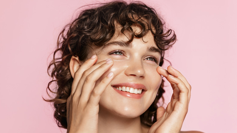 A woman applying skincare product