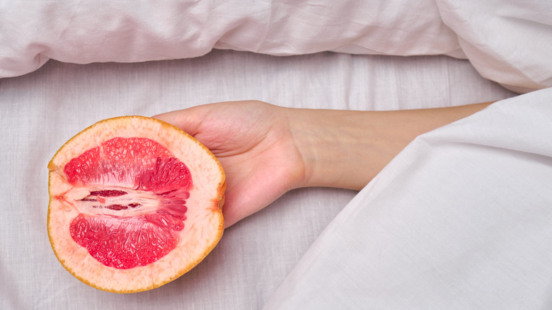 woman holding suggestive grapefruit