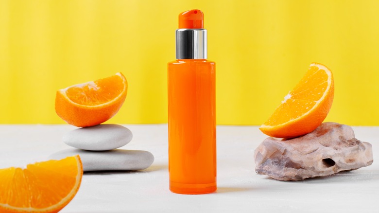 orange dispenser bottle with cut tangerine pieces sitting in the back 