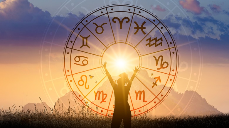 woman standing in front of sunshine with zodiac signs