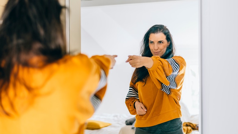 woman pointing at herself in the mirror