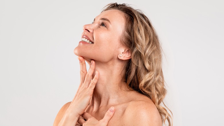 woman adding skincare to neck