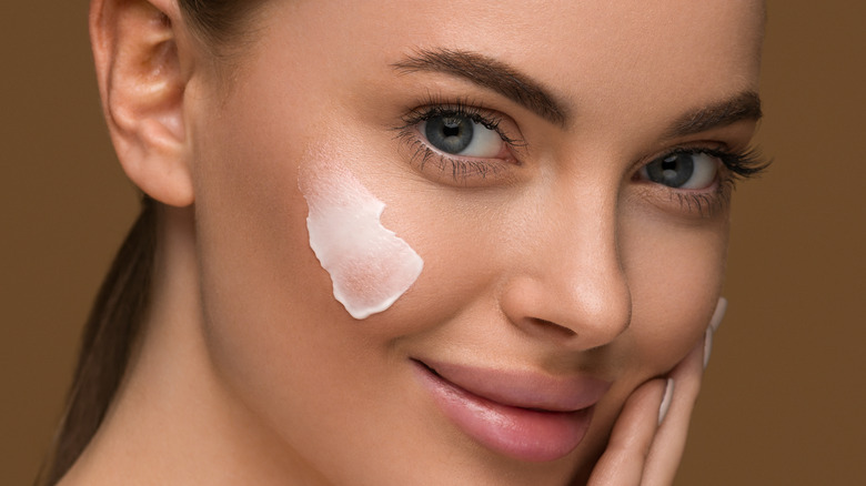 close up of woman with skincare on cheek