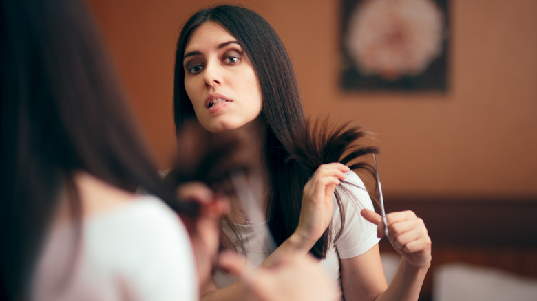 A woman cutting her own hair