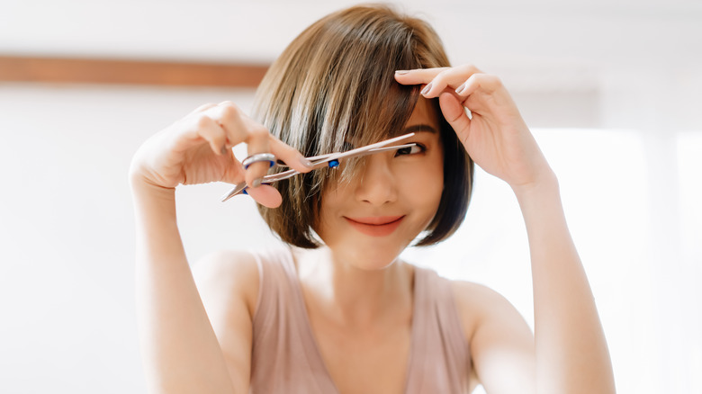 A woman trimming her hair ends