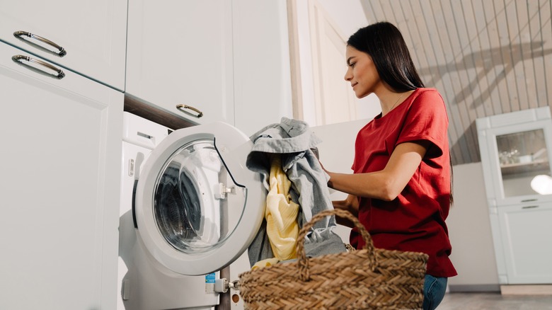 Woman doing a load of washing in laundry facility