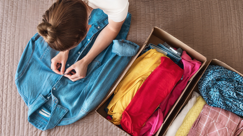 Woman preparing to donate clothing to charity