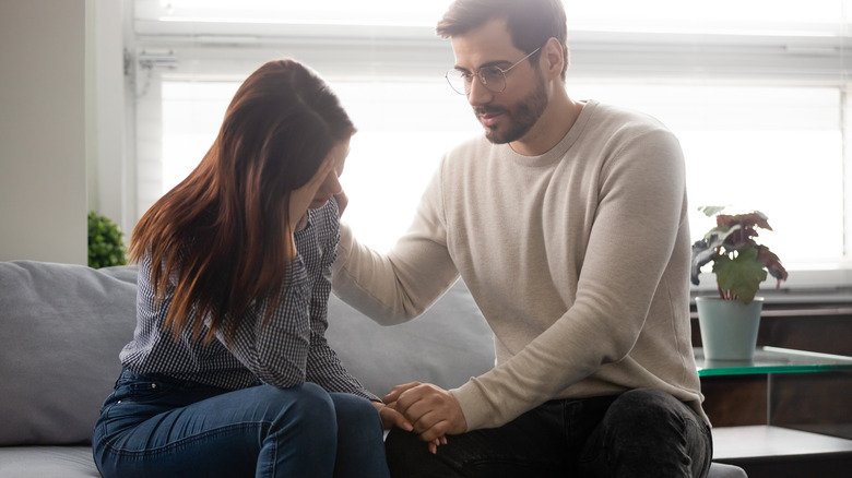 Man reassuring a woman