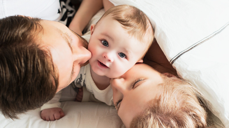 Parents kissing baby's cheeks