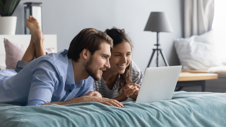 smiling couple looking at laptop