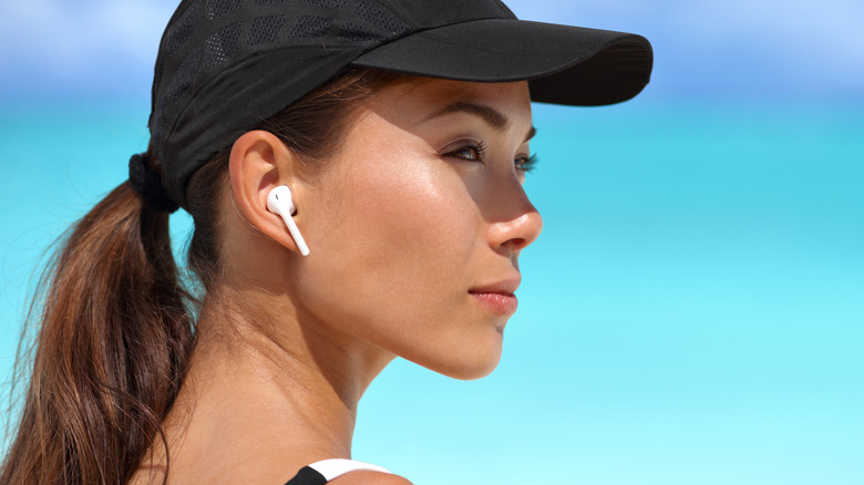 woman wearing black sports hat and airpods